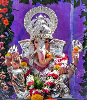 Portrait , closeup view of decorated and garlanded idol of Hindu God Ganesha in Pune, India.