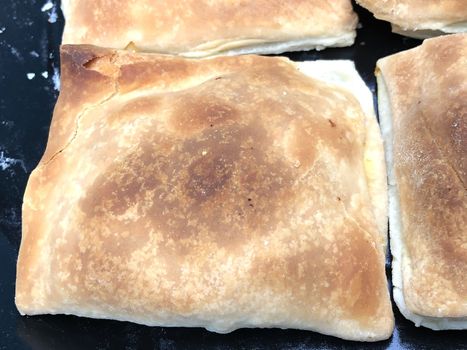 Full frame view of vegetable puffs kept in a plate for sale in the bakery after cooking in a microwave oven