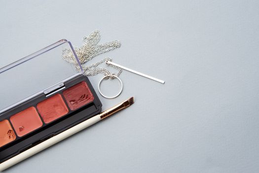 palette with lipstick and makeup brushes for makeup gray background. High quality photo