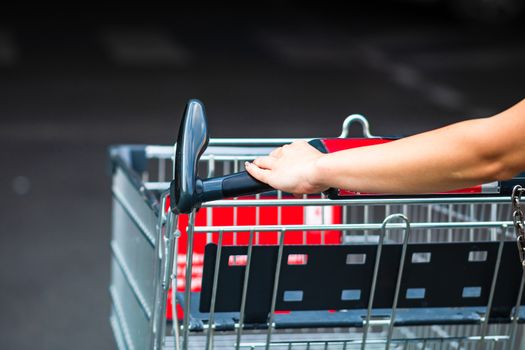 Close up of woman hands pushing empty shopping cart isolated in Bucharest, Romania, 2020