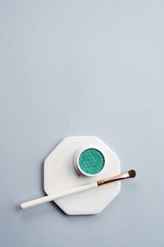 Green eyeshadow and makeup brush on white stand isolated background. High quality photo