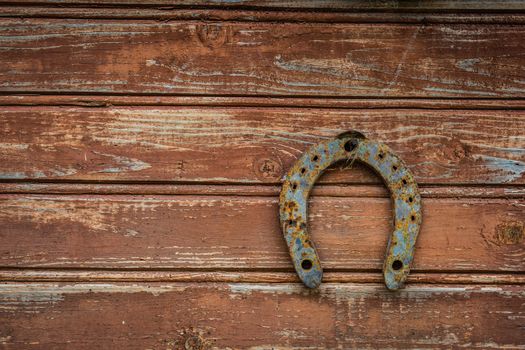 Horseshoe on a brown wooden door old wall background for good luck.