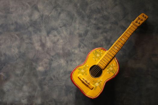 Spanish guitar toy on a gray background. Copy space.