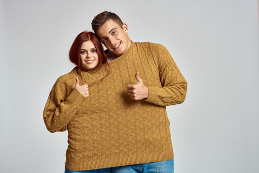 couple in yellow sweater posing against light background cropped view. High quality photo