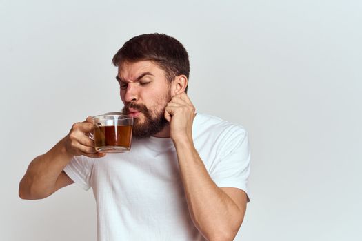 man with a cup of tea in a bag on a light background Hot drink cropped view model. High quality photo