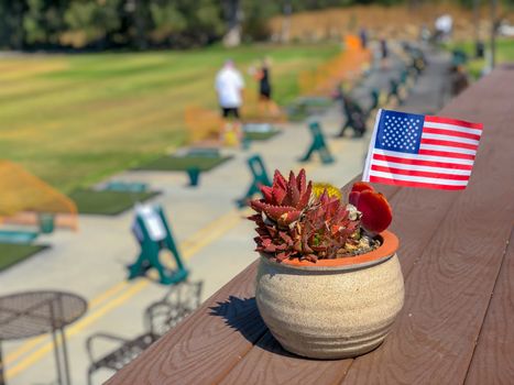 Patriotic flower pot with American flags and golfer on the background. American flag decoration.