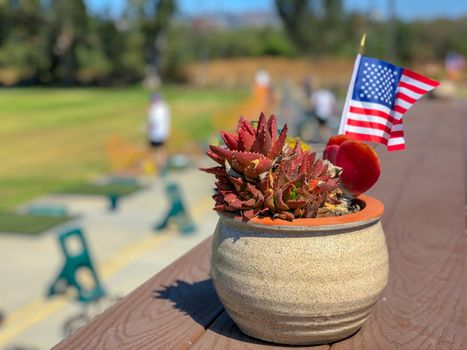 Patriotic flower pot with American flags and golfer on the background. American flag decoration.