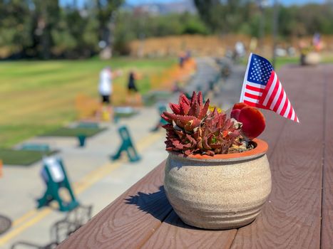 Patriotic flower pot with American flags and golfer on the background. American flag decoration.