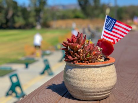 Patriotic flower pot with American flags and golfer on the background. American flag decoration.