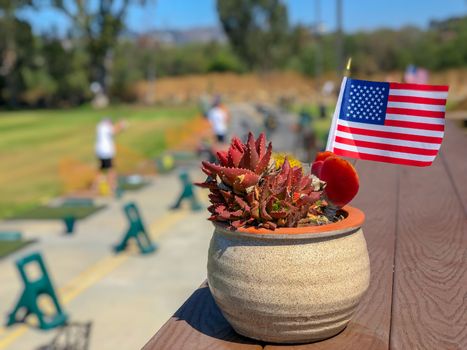 Patriotic flower pot with American flags and golfer on the background. American flag decoration.