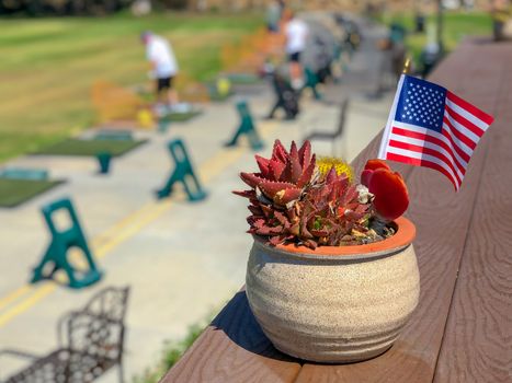 Patriotic flower pot with American flags and golfer on the background. American flag decoration.