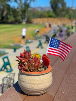 Patriotic flower pot with American flags and golfer on the background. American flag decoration.