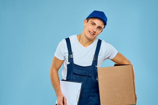 Man worker with cardboard box delivery loader lifestyle blue background. High quality photo