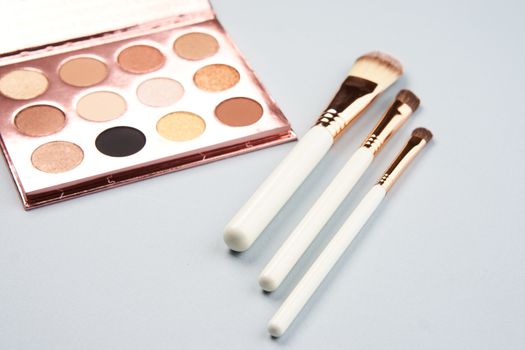 eyeshadow makeup brushes collection professional cosmetics accessories beads on gray background. High quality photo