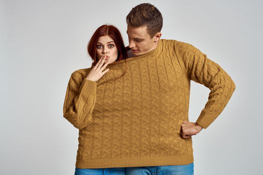 couple in yellow sweater posing against light background cropped view. High quality photo