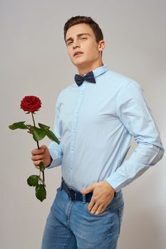 romantic man with red rose and light shirt pants suit. High quality photo