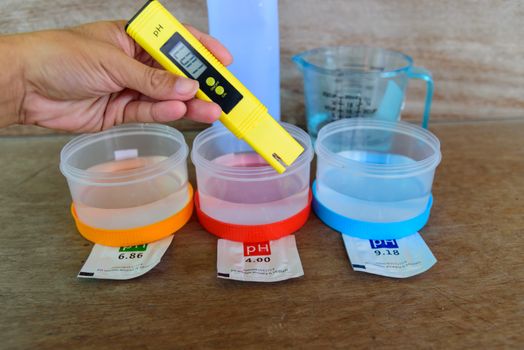The man calibrate Ph meter before use it for tester