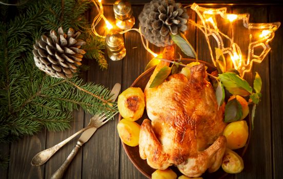 roasted chicken on black wooden background with holiday illumination