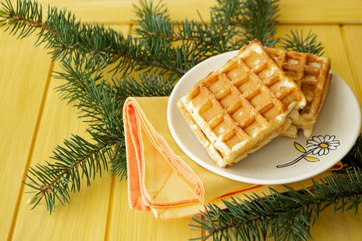 Homemade fresh golden waffles delicious breakfast. Christmas decoration on yellow background