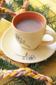 Christmas hot chocolate in a orange cup on orange wooden board. Vertical image