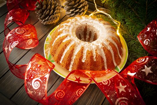 Traditional homemade christmas cake holiday dessert in new year tree decorations frame on vintage wooden table background.