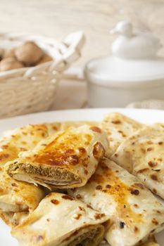 Pancakes filled with meat stuffing on a white plate, rolled pancakes, vertical image