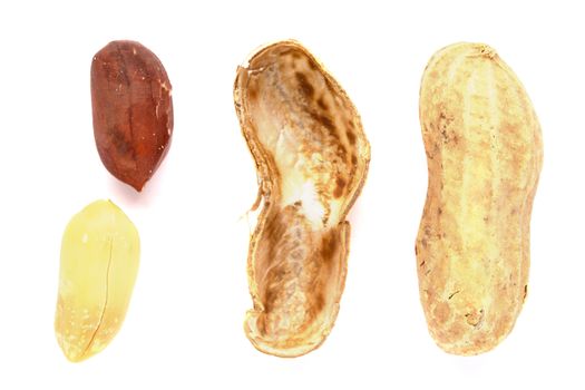 Some peanuts with the shell next to them on a white background