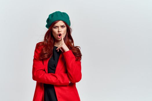 Woman in red coat and in green hat on isolated background cropped model with Copy Space emotions. High quality photo