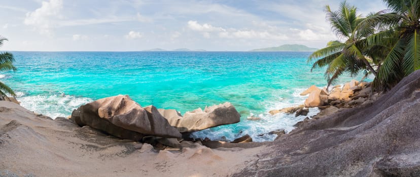 The beach of the Seychelles with blue water and stones