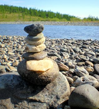 Stones folded on top of each other on the river bank.