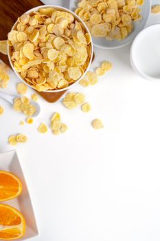 Top view of corn flakes bowl sweeties with milk and orange on white background, flat lay overhead layout, fresh and healthy breakfast design concept.