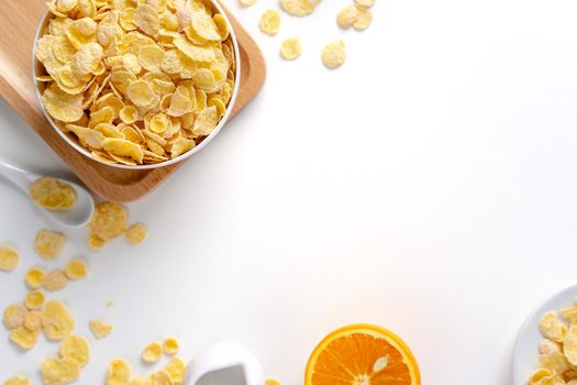 Top view of corn flakes bowl sweeties with milk and orange on white background, flat lay overhead layout, fresh and healthy breakfast design concept.