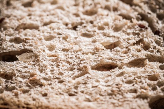 Fresh whole grain seeded bread, organic wheat flour, closeup slice texture as background for food blog or cook book recipes