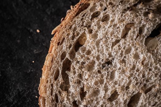 Fresh whole grain seeded bread, organic wheat flour, closeup slice texture as background for food blog or cook book recipes