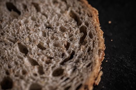 Fresh whole grain seeded bread, organic wheat flour, closeup slice texture as background for food blog or cook book recipes