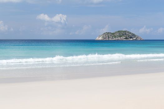 A beach on the Seychelles island with white sand and stones