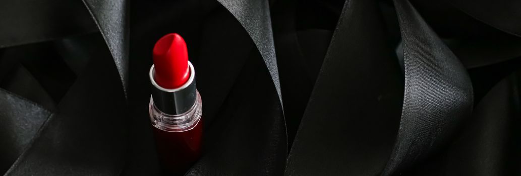 Red lipstick on black silk background, luxury make-up and beauty cosmetics