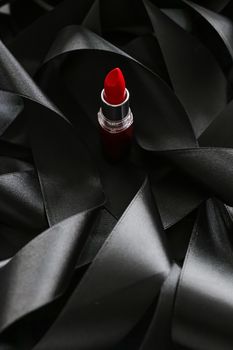 Red lipstick on black silk background, luxury make-up and beauty cosmetics