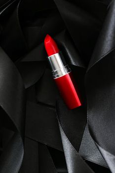 Red lipstick on black silk background, luxury make-up and beauty cosmetics