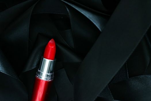 Red lipstick on black silk background, luxury make-up and beauty cosmetics