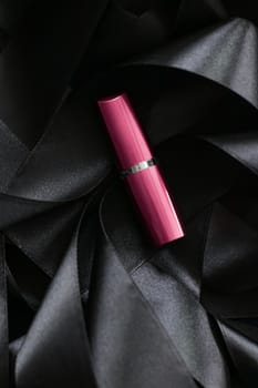 Pink lipstick on black silk background, luxury make-up and beauty cosmetics