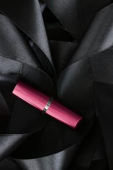 Pink lipstick on black silk background, luxury make-up and beauty cosmetics