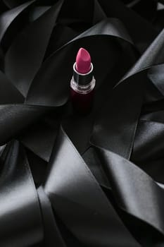 Pink lipstick on black silk background, luxury make-up and beauty cosmetics