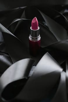 Pink lipstick on black silk background, luxury make-up and beauty cosmetics