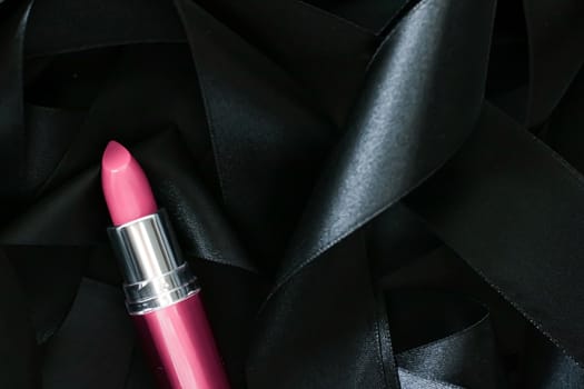 Pink lipstick on black silk background, luxury make-up and beauty cosmetics