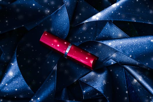 Red lipstick on blue silk and shiny glitter background, luxury make-up and beauty cosmetics