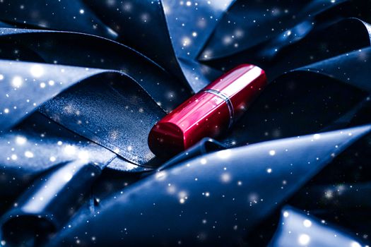 Red lipstick on blue silk and shiny glitter background, luxury make-up and beauty cosmetics