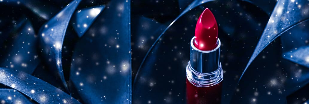 Red lipstick on blue silk and shiny glitter background, luxury make-up and beauty cosmetics