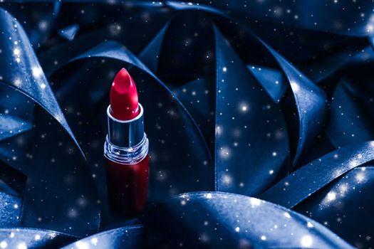 Red lipstick on blue silk and shiny glitter background, luxury make-up and beauty cosmetics