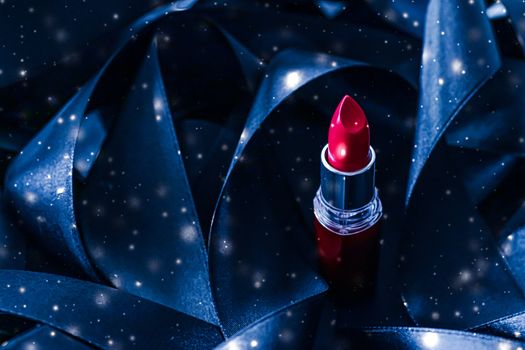 Red lipstick on blue silk and shiny glitter background, luxury make-up and beauty cosmetics